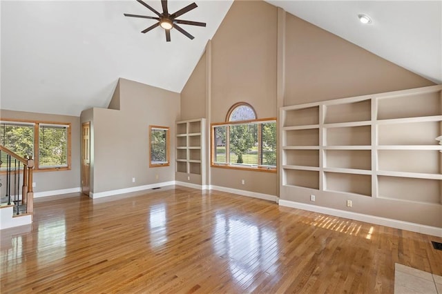 1125 S Mulberry St, Ottawa, KS 66067 - unfurnished living room featuring high vaulted ceiling, ceiling fan, wood finished floors, and stairs