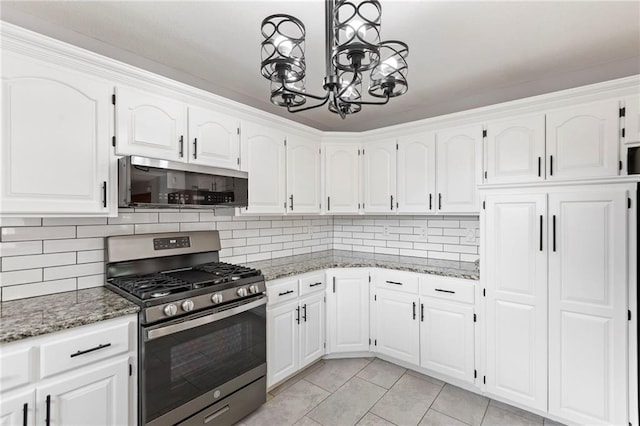 1125 S Mulberry St, Ottawa, KS 66067 - kitchen featuring stainless steel appliances, a chandelier, light tile patterned floors, light stone countertops, and white cabinetry