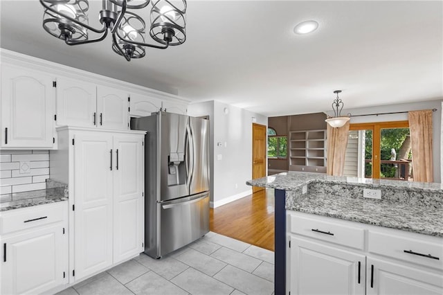 1125 S Mulberry St, Ottawa, KS 66067 - kitchen with stainless steel refrigerator with ice dispenser, light tile patterned flooring, white cabinets, tasteful backsplash, and a chandelier