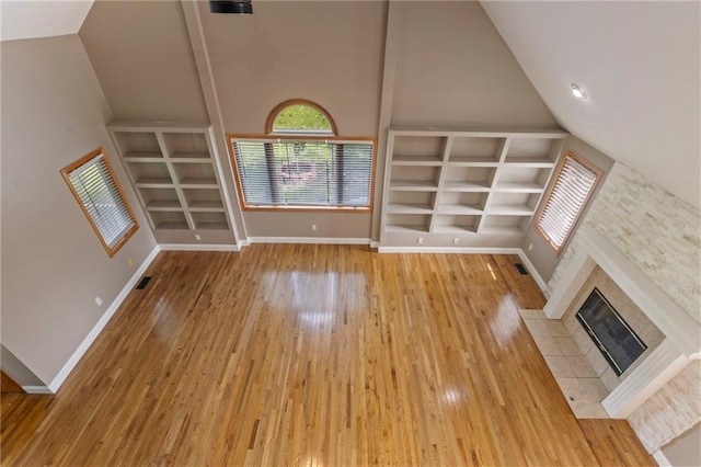 1125 S Mulberry St, Ottawa, KS 66067 - unfurnished living room with vaulted ceiling, built in shelves, wood finished floors, and a fireplace