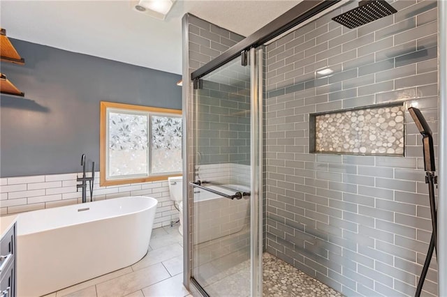 1125 S Mulberry St, Ottawa, KS 66067 - bathroom with a stall shower, tile walls, a soaking tub, and tile patterned flooring