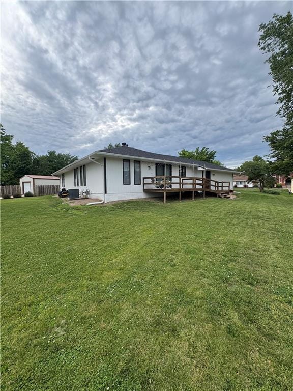 109 W 3rd St, Stanberry, MO 64489 - back of property with a lawn, a deck, and an outdoor structure