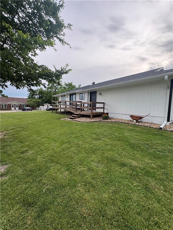109 W 3rd St, Stanberry, MO 64489 - back of house featuring a deck and a lawn