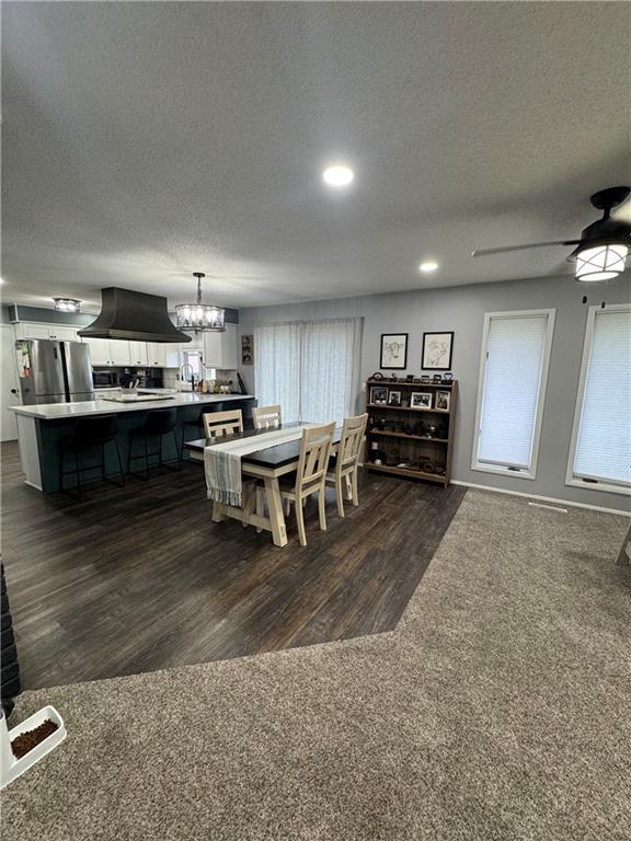 109 W 3rd St, Stanberry, MO 64489 - dining room featuring a textured ceiling, a chandelier, dark wood-type flooring, a ceiling fan, and recessed lighting