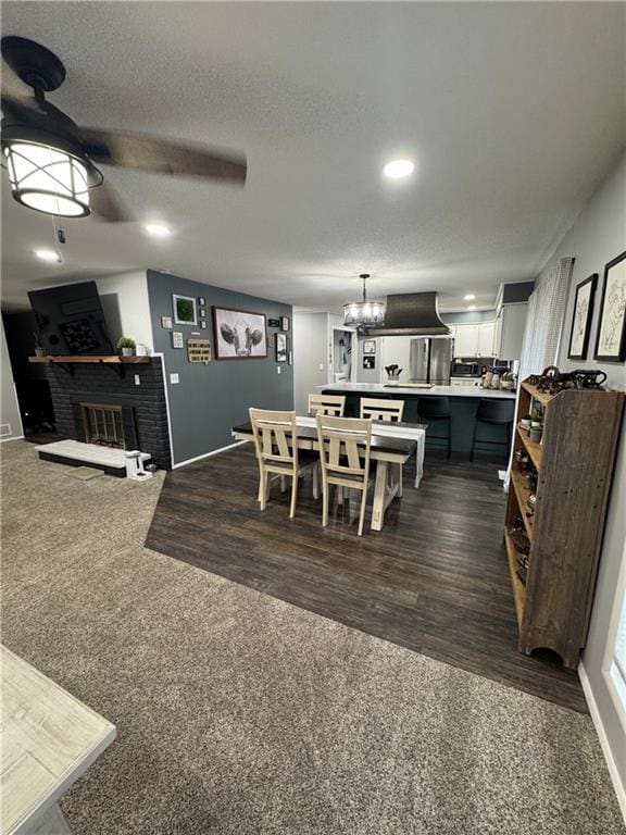 109 W 3rd St, Stanberry, MO 64489 - dining area with a fireplace, recessed lighting, dark colored carpet, dark wood-style floors, and a chandelier