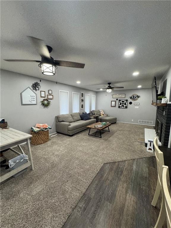 109 W 3rd St, Stanberry, MO 64489 - living area featuring a ceiling fan, a textured ceiling, a brick fireplace, wood finished floors, and recessed lighting