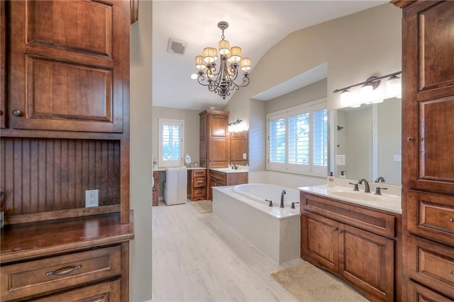 6 Mohave Dr, Lake Winnebago, MO 64034 - bathroom with lofted ceiling, a garden tub, two vanities, wood finished floors, and a chandelier
