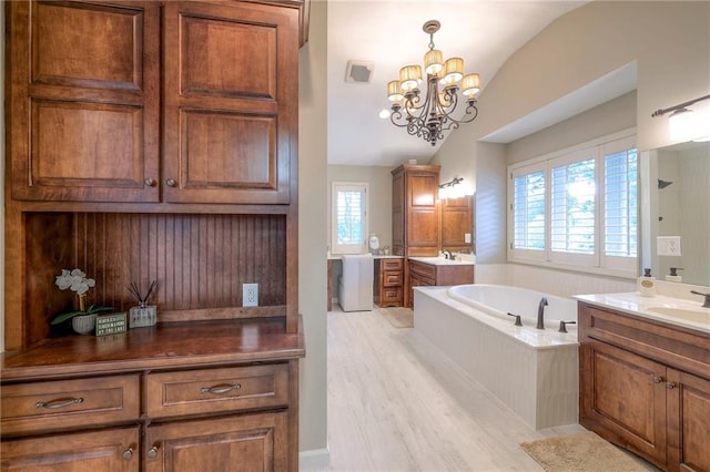 6 Mohave Dr, Lake Winnebago, MO 64034 - bathroom with vaulted ceiling, plenty of natural light, two vanities, a garden tub, and a chandelier