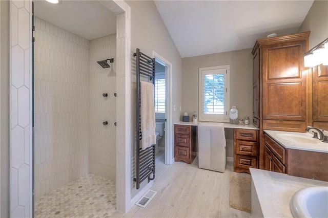 6 Mohave Dr, Lake Winnebago, MO 64034 - bathroom with tiled shower, vanity, wood finished floors, lofted ceiling, and a towel warming rack
