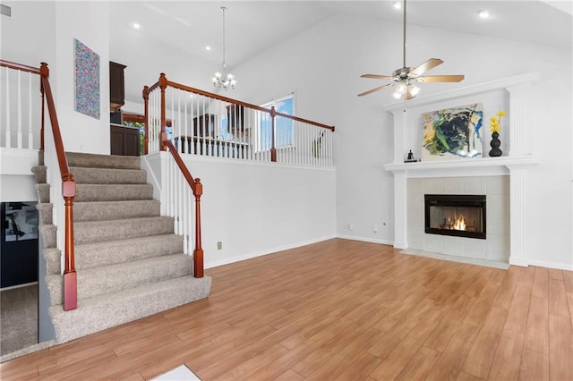 16778 W 156th Ter, Olathe, KS 66062 - unfurnished living room with stairway, high vaulted ceiling, a fireplace, light wood-style flooring, and ceiling fan