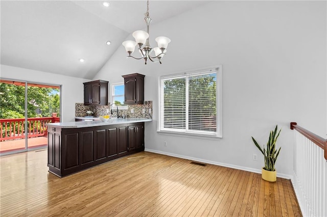 16778 W 156th Ter, Olathe, KS 66062 - kitchen featuring light countertops, a chandelier, light wood finished floors, dark brown cabinets, and a peninsula