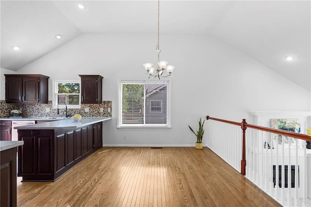 16778 W 156th Ter, Olathe, KS 66062 - kitchen with a chandelier, dark brown cabinetry, hanging light fixtures, light wood finished floors, and decorative backsplash