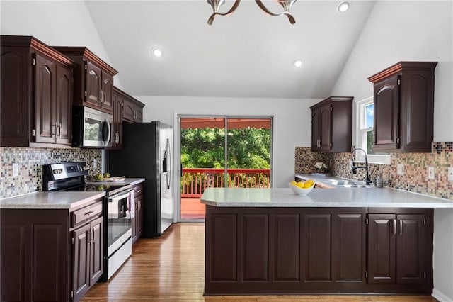 16778 W 156th Ter, Olathe, KS 66062 - kitchen with stainless steel appliances, lofted ceiling, light countertops, dark brown cabinetry, and plenty of natural light