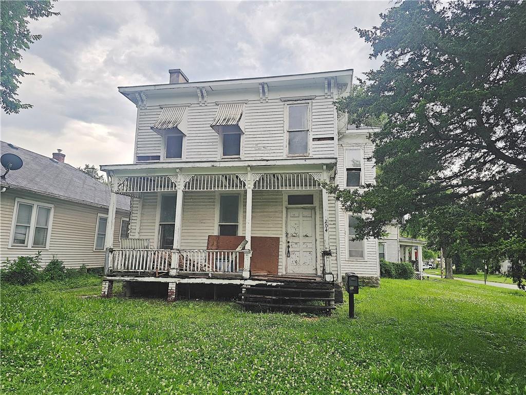 204 S Elm St, Ottawa, KS 66067 - rear view of property with a porch and a lawn