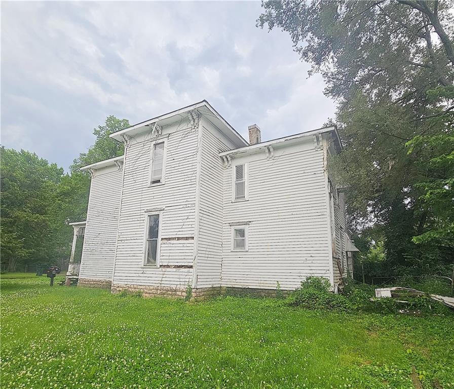 204 S Elm St, Ottawa, KS 66067 - view of home's exterior with a chimney and a lawn