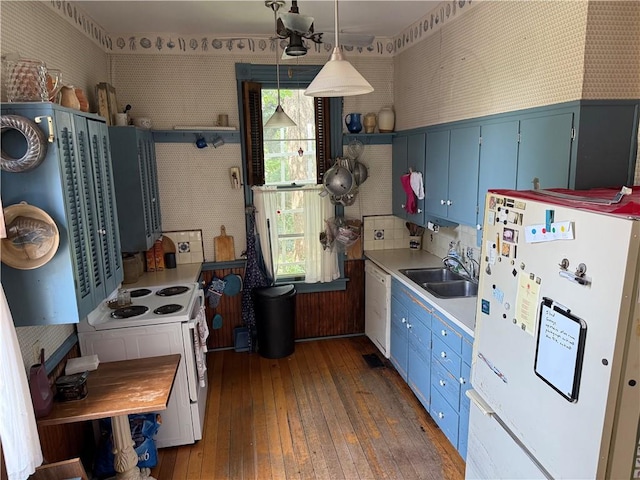 222 W Gay St, Warrensburg, MO 64093 - kitchen with white appliances, blue cabinetry, wood-type flooring, and light countertops