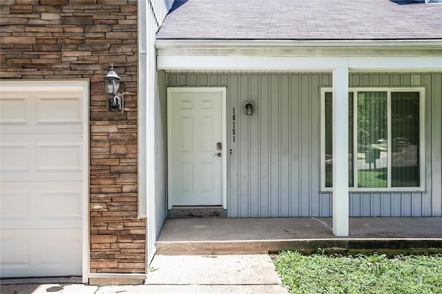 10151 W 84th St, Overland Park, KS 66212 - view of exterior entry featuring board and batten siding, a shingled roof, and an attached garage