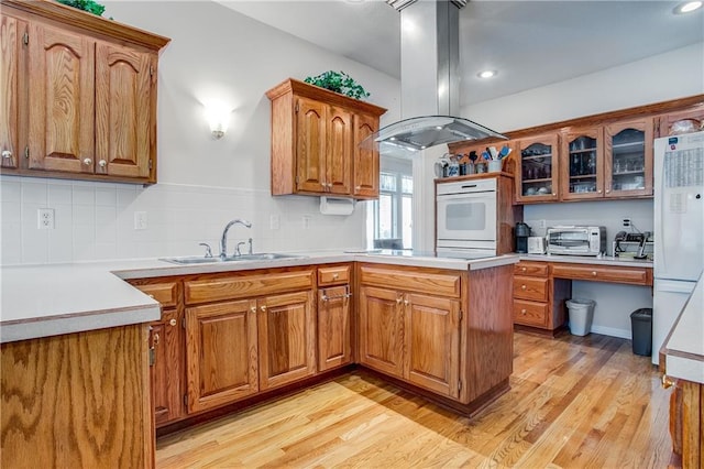 17801 E 30th St S, Independence, MO 64057 - kitchen with island exhaust hood, white appliances, a peninsula, brown cabinets, and recessed lighting