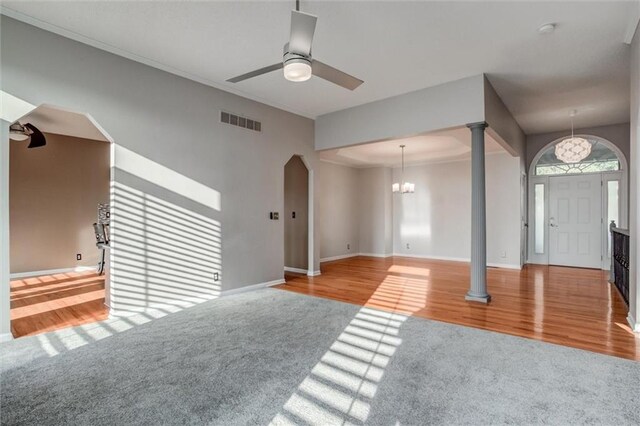 12546 Augusta Dr, Kansas City, KS 66109 - unfurnished living room with carpet flooring, decorative columns, a ceiling fan, and wood finished floors