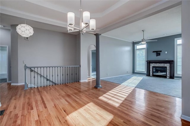 12546 Augusta Dr, Kansas City, KS 66109 - unfurnished living room featuring ceiling fan, wood finished floors, a glass covered fireplace, crown molding, and a chandelier