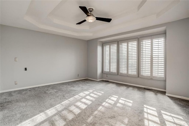 12546 Augusta Dr, Kansas City, KS 66109 - spare room featuring a tray ceiling, ceiling fan, and carpet