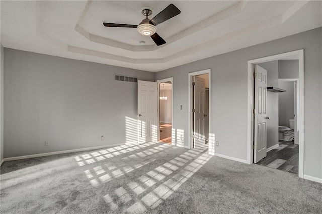 12546 Augusta Dr, Kansas City, KS 66109 - unfurnished bedroom with a tray ceiling, carpet floors, a spacious closet, and ensuite bathroom