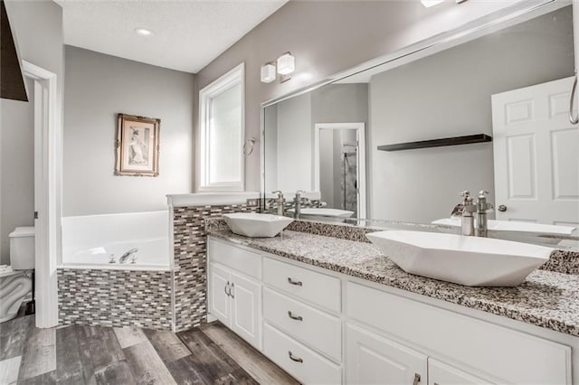 12546 Augusta Dr, Kansas City, KS 66109 - bathroom with double vanity, a garden tub, and wood finished floors