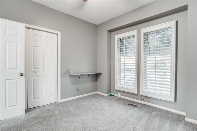 12546 Augusta Dr, Kansas City, KS 66109 - unfurnished bedroom featuring carpet floors, multiple windows, and a closet