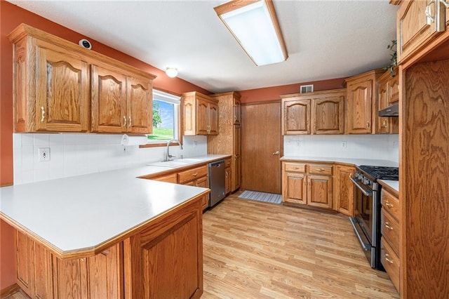 11180 Riverview Ave, Edwardsville, KS 66111 - kitchen with stainless steel appliances, a peninsula, light wood-type flooring, and decorative backsplash