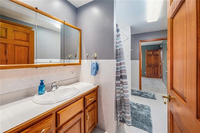 11180 Riverview Ave, Edwardsville, KS 66111 - full bath with vanity, tile patterned floors, a shower with shower curtain, tile walls, and a wainscoted wall