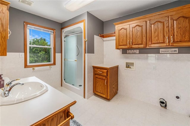 11180 Riverview Ave, Edwardsville, KS 66111 - bathroom featuring tile walls, a stall shower, a wainscoted wall, and vanity