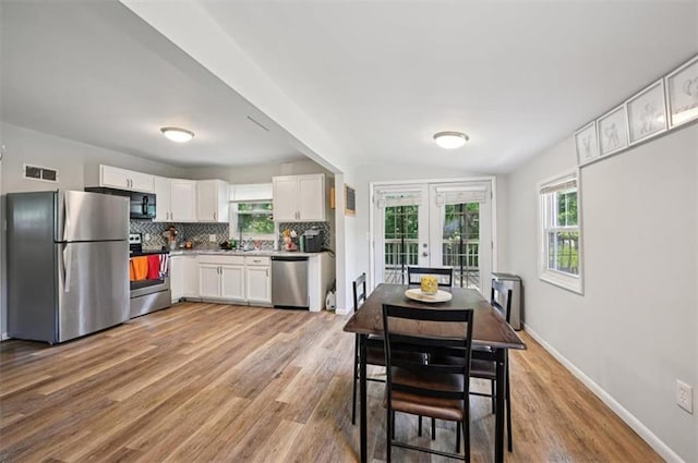 919 Walnut St, Leavenworth, KS 66048 - dining space featuring plenty of natural light, french doors, and light wood-type flooring