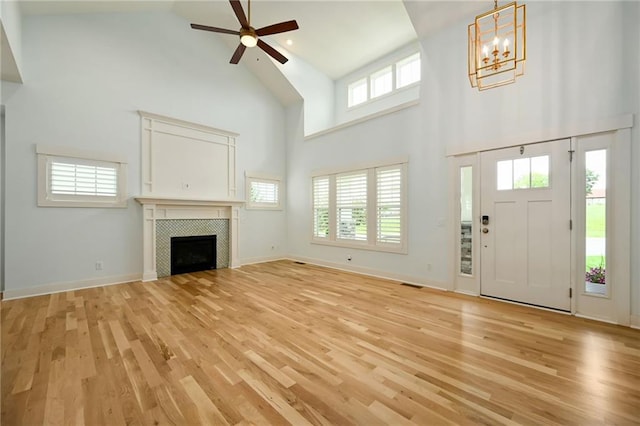 3225 SW Longview Rd, Lees Summit, MO 64081 - unfurnished living room featuring high vaulted ceiling, light wood-type flooring, ceiling fan, a chandelier, and a fireplace
