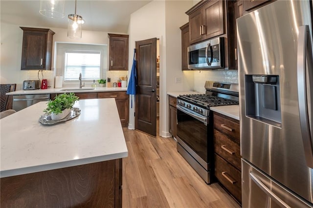 1301 NE 123rd St, Kansas City, MO 64165 - kitchen featuring stainless steel appliances, light wood-type flooring, dark brown cabinetry, and tasteful backsplash