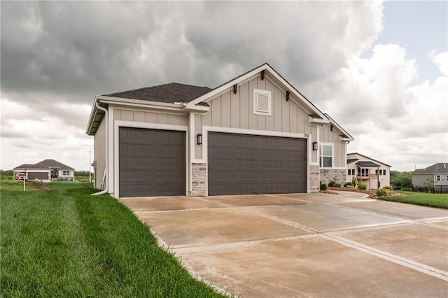 1301 NE 123rd St, Kansas City, MO 64165 - view of front of property with board and batten siding, an attached garage, driveway, stone siding, and a front yard