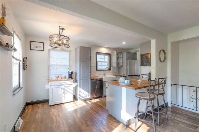 1108 NW Canterbury Rd, Blue Springs, MO 64015 - kitchen with wooden counters, stainless steel appliances, wood finished floors, tasteful backsplash, and recessed lighting