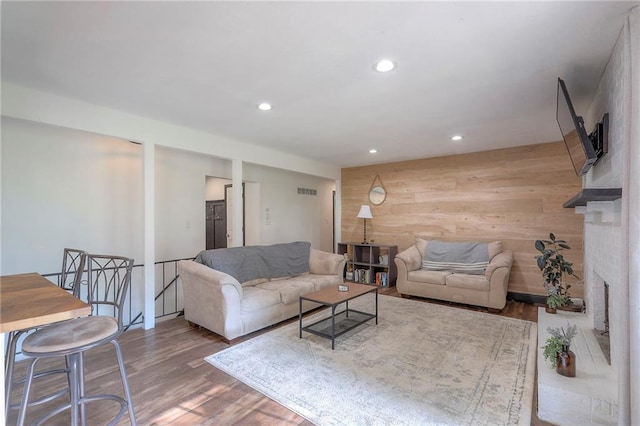 1108 NW Canterbury Rd, Blue Springs, MO 64015 - living area with wooden walls, recessed lighting, wood finished floors, and a brick fireplace