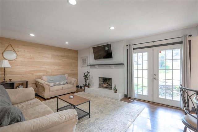 1108 NW Canterbury Rd, Blue Springs, MO 64015 - living area with french doors, wood walls, recessed lighting, wood finished floors, and a large fireplace