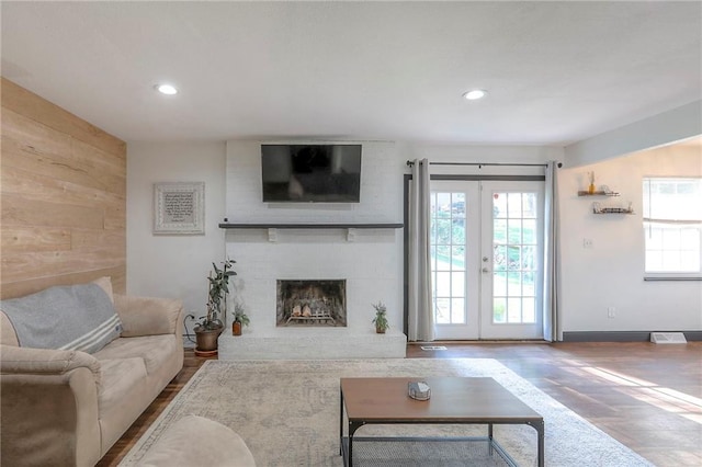 1108 NW Canterbury Rd, Blue Springs, MO 64015 - living room featuring healthy amount of natural light, wood finished floors, french doors, wood walls, and recessed lighting