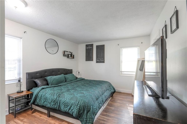 1108 NW Canterbury Rd, Blue Springs, MO 64015 - bedroom with multiple windows, wood finished floors, and a textured ceiling
