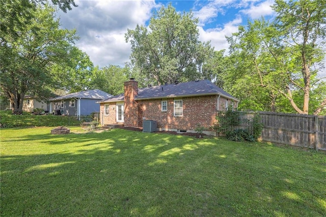 1108 NW Canterbury Rd, Blue Springs, MO 64015 - rear view of house with an outdoor fire pit, a chimney, and brick siding