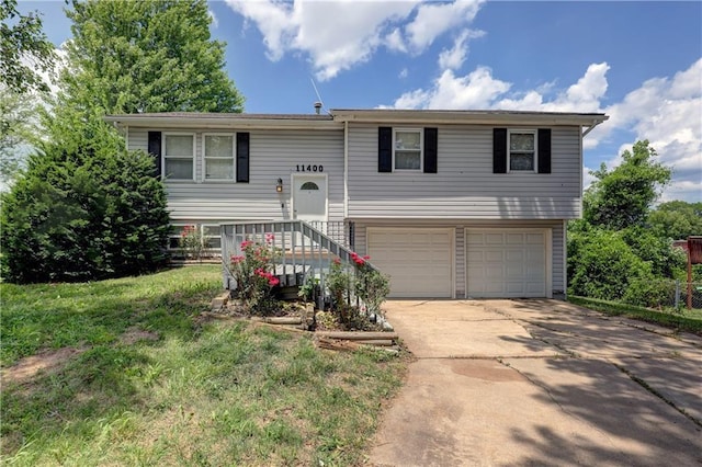 11400 Monroe Ave, Kansas City, MO 64137 - bi-level home with a garage, concrete driveway, and a front yard