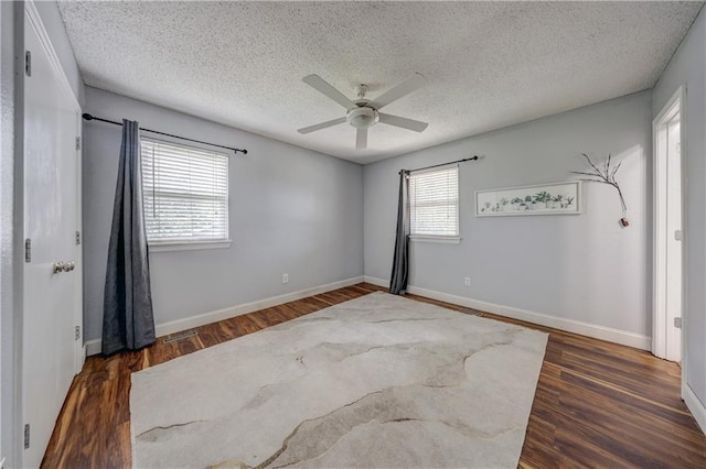 11400 Monroe Ave, Kansas City, MO 64137 - unfurnished room with a ceiling fan, dark wood finished floors, and a textured ceiling