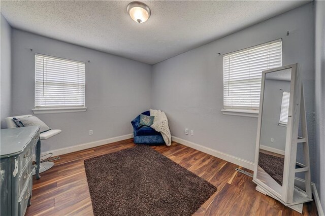 11400 Monroe Ave, Kansas City, MO 64137 - sitting room with plenty of natural light, wood finished floors, and a textured ceiling