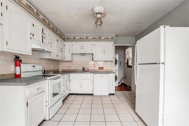 11301 Deer Haven Ln, Excelsior Springs, MO 64024 - kitchen featuring white appliances, estacked washer and dryer, under cabinet range hood, and white cabinetry
