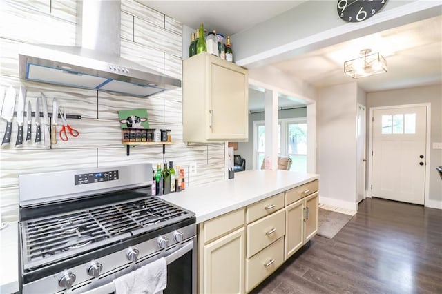 2633 E Langsford Rd, Lees Summit, MO 64063 - kitchen featuring stainless steel range with gas cooktop, wall chimney range hood, cream cabinetry, dark wood finished floors, and tasteful backsplash