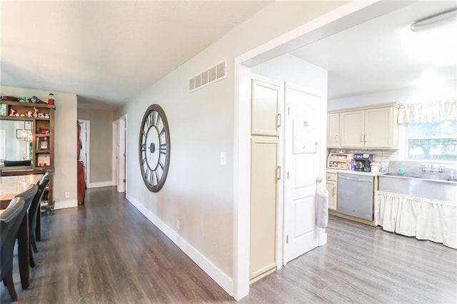 2633 E Langsford Rd, Lees Summit, MO 64063 - kitchen featuring stainless steel dishwasher, wood finished floors, light countertops, and backsplash