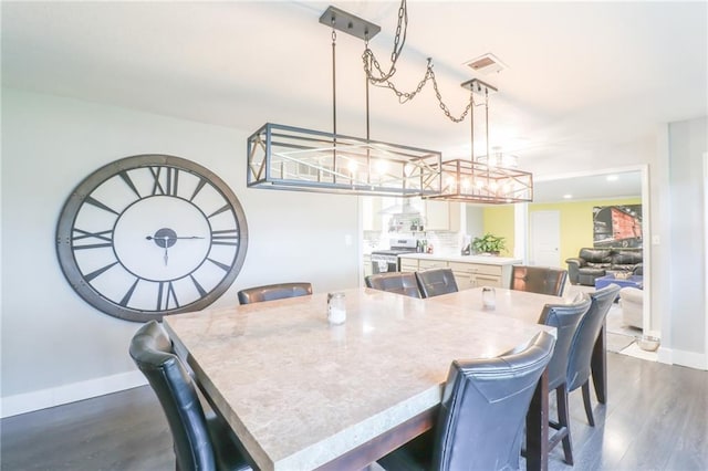 2633 E Langsford Rd, Lees Summit, MO 64063 - dining area with dark wood finished floors, a chandelier, and recessed lighting
