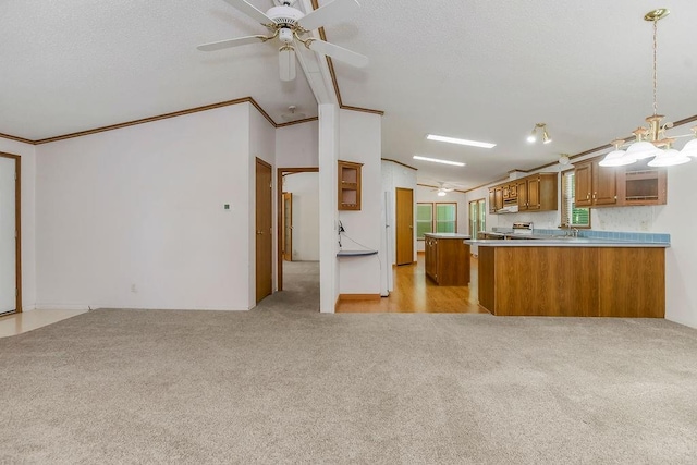 81 Enchanted Ln, Linn Valley, KS 66040 - kitchen featuring brown cabinets, vaulted ceiling, light carpet, ceiling fan, and a peninsula