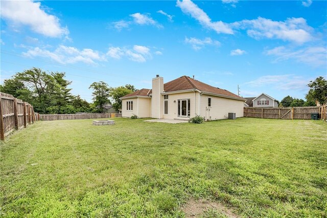 7210 E 134th Ter, Grandview, MO 64030 - back of property with a chimney, a fire pit, a patio, and a fenced backyard